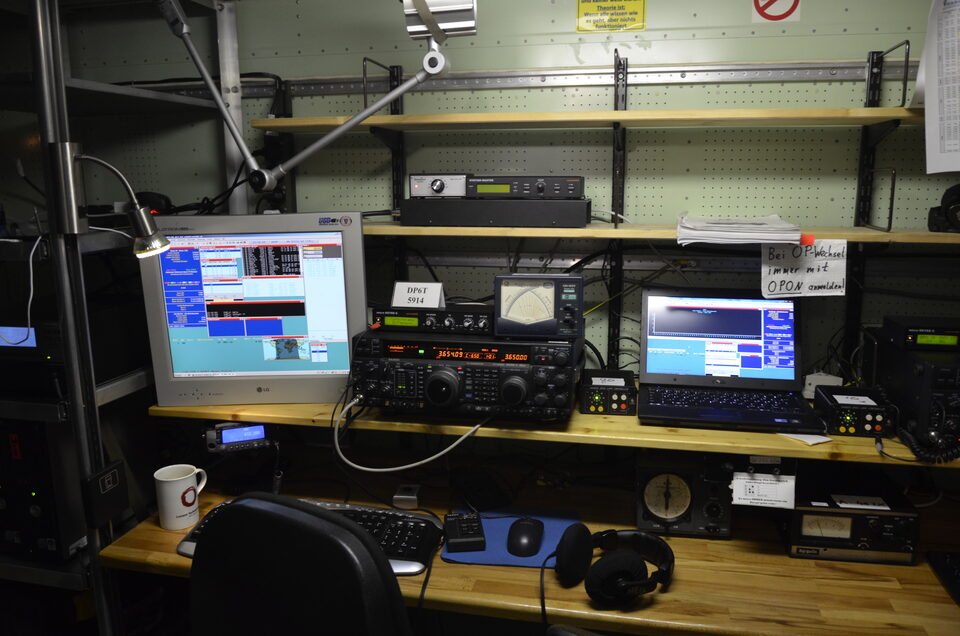 A ham radio operating station with transceivers and headphones